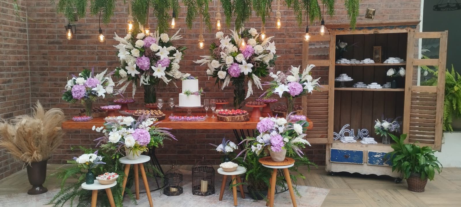 Mesa decorada com flores e bolo de casamento